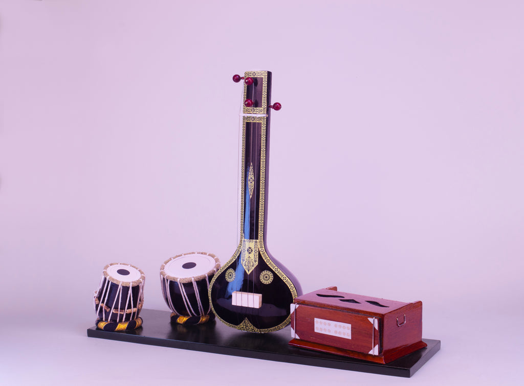 Model of a sitar and two small drums on a stand with a purple background